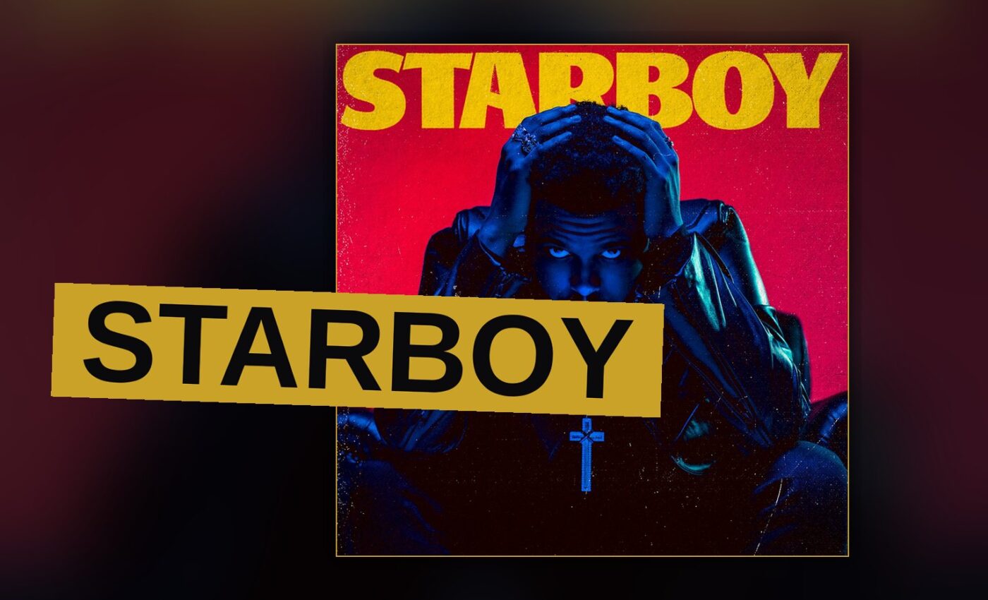 A pop star stands under a glowing star-shaped light on a dark stage.