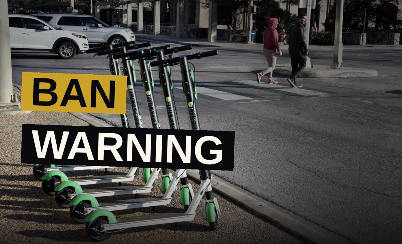 Students riding electric scooters and e-bikes navigate a crowded walkway on a college campus.