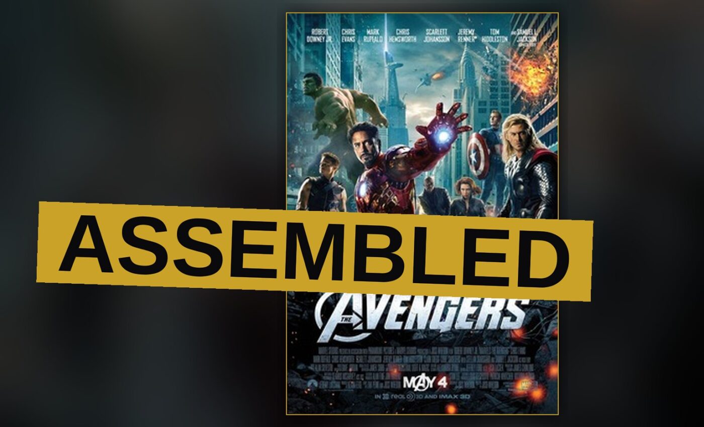 The Avengers team stands together on a New York street, with the Hulk roaring and Iron Man flying overhead amid alien ships.