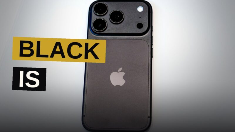 A black iPhone 18 Pro displayed on a dark surface under soft studio lighting.