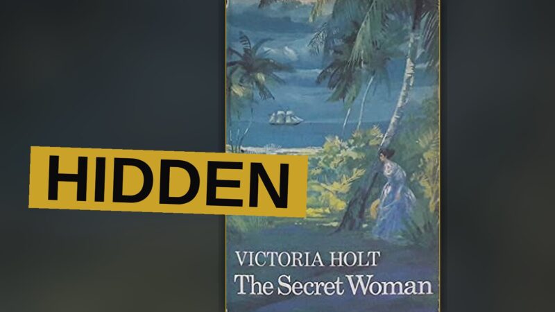 A woman hides in a dim room, fear etched upon her face.