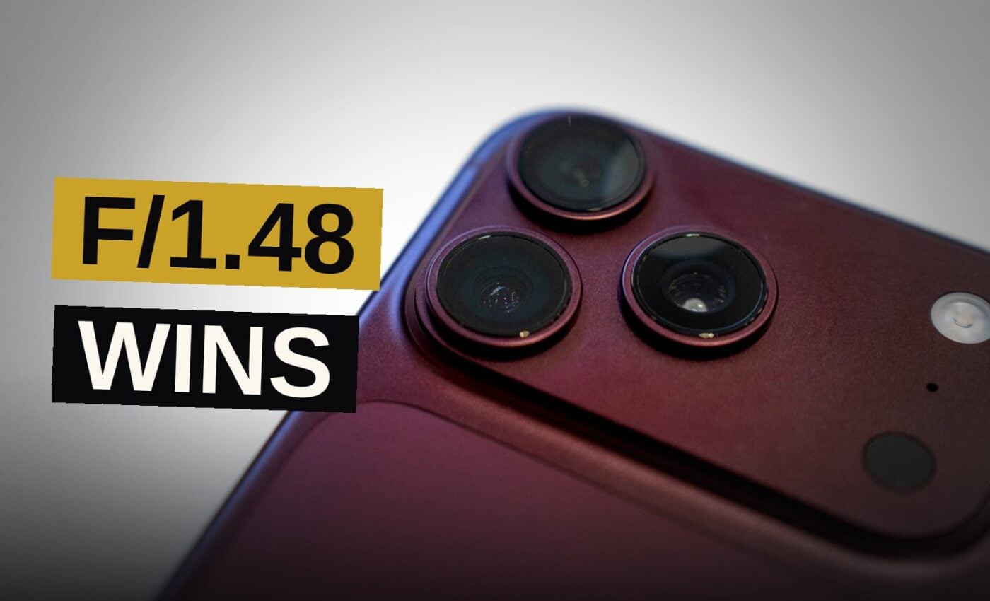 Close-up of an iPhone 18 Pro camera housing with a metallic iris ring and glass lens on a dark surface.