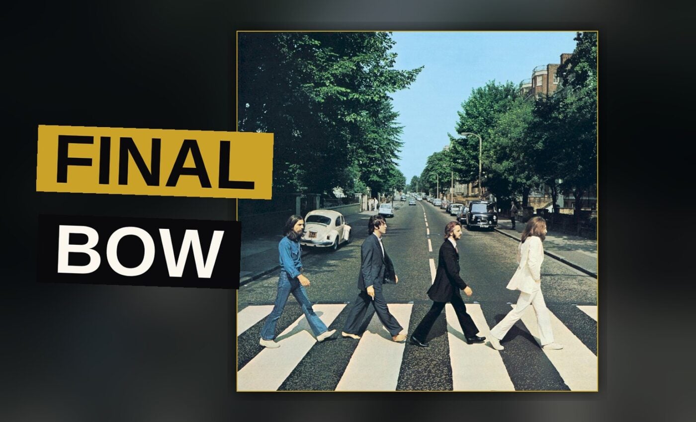 A vinyl record spins on a record player, the Abbey Road album cover leaning beside it in warm light.