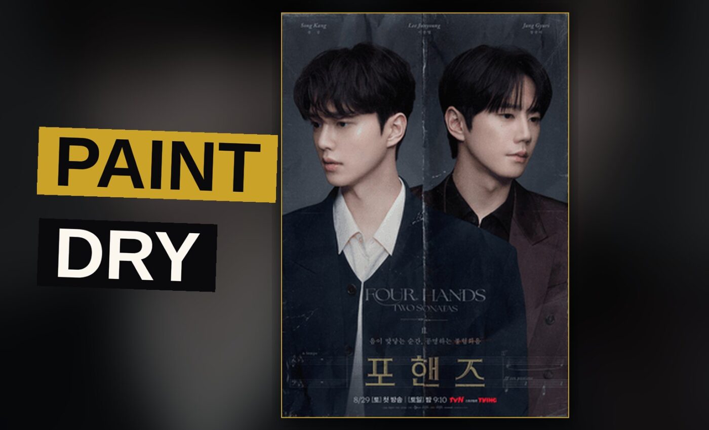 Two pianists sit together at a grand piano, their hands poised above the keys in solemn silence.