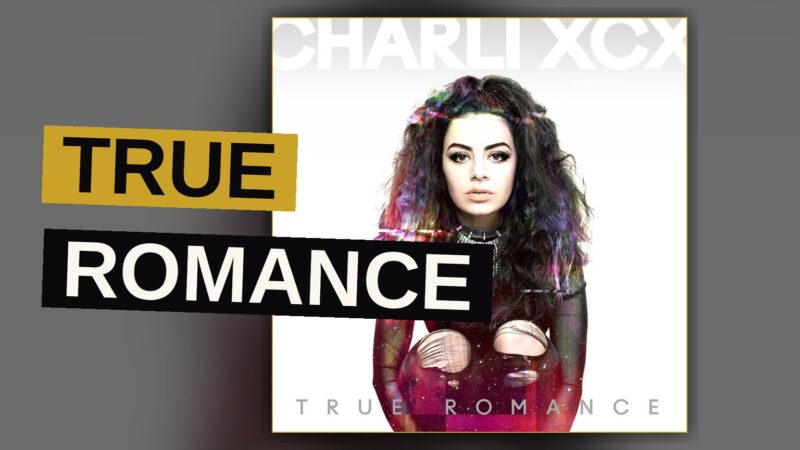 A pop singer performs under colored stage lights evoking a retro 90s girl group aesthetic.