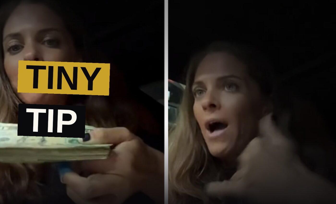 A waitress in a diner holds a receipt and a few dollar bills, looking disappointed.