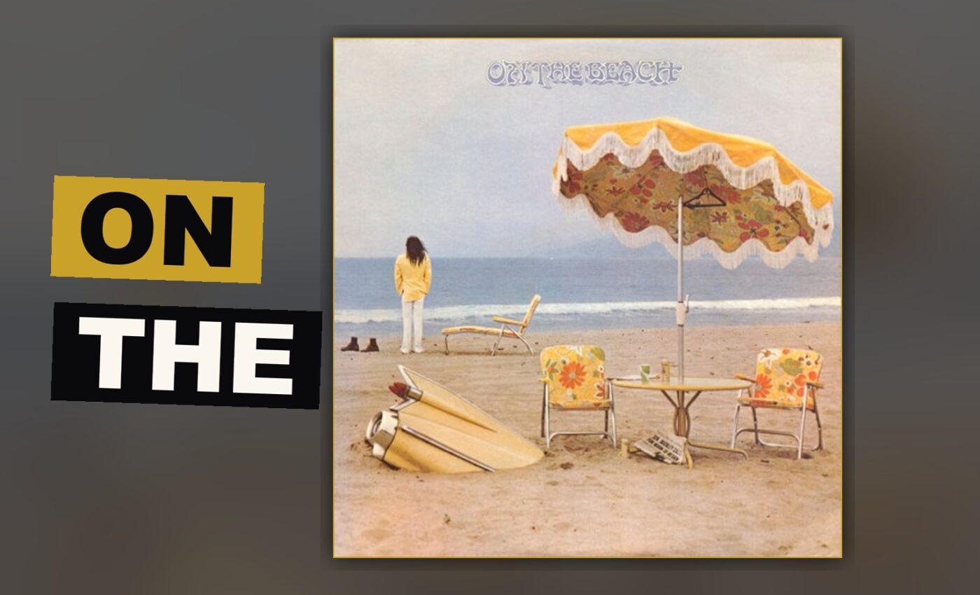 A solitary man sits upon a desolate beach, a buried automobile beside him, beneath a sky heavy with despair.